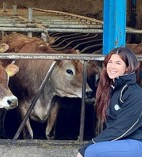 Julia Wadeson  kneeling beside a cow